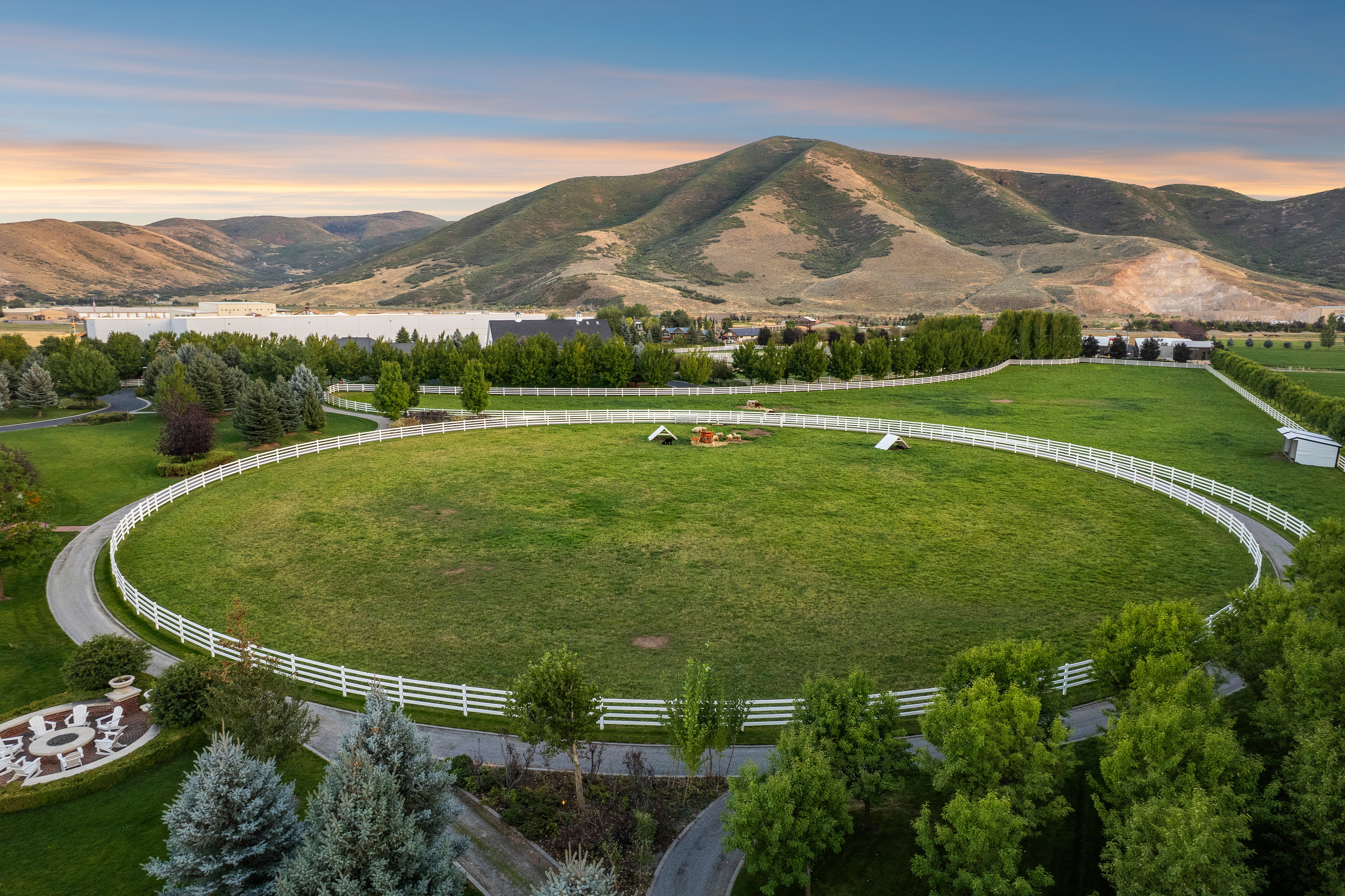 Expansive green pasture framed by white fencing