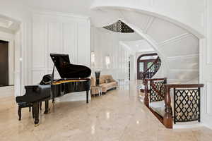 Entrance foyer with a decorative wall, arched walkways, and ornamental molding