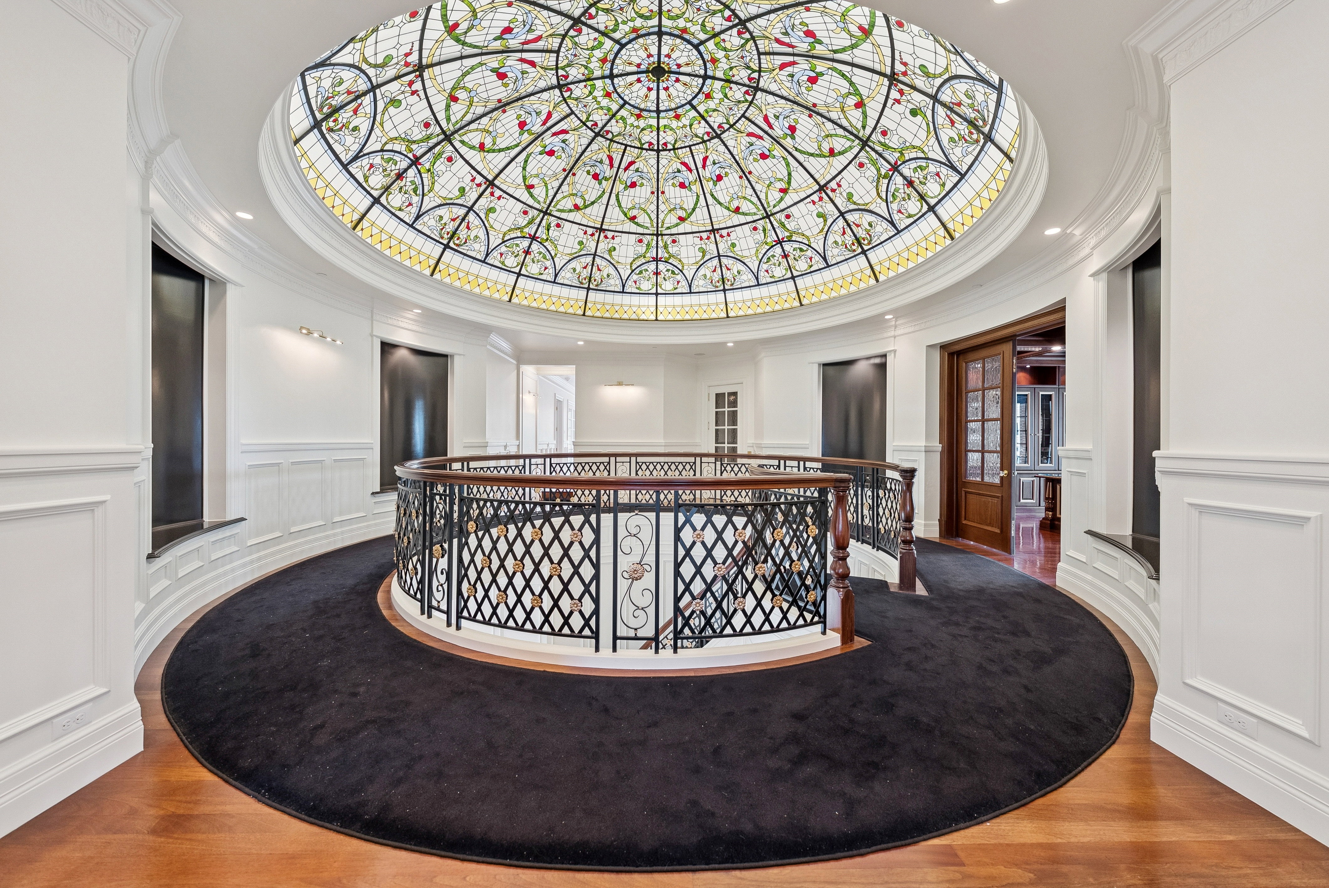 Ornate stained-glass dome ceiling crowning a grand circular hallway