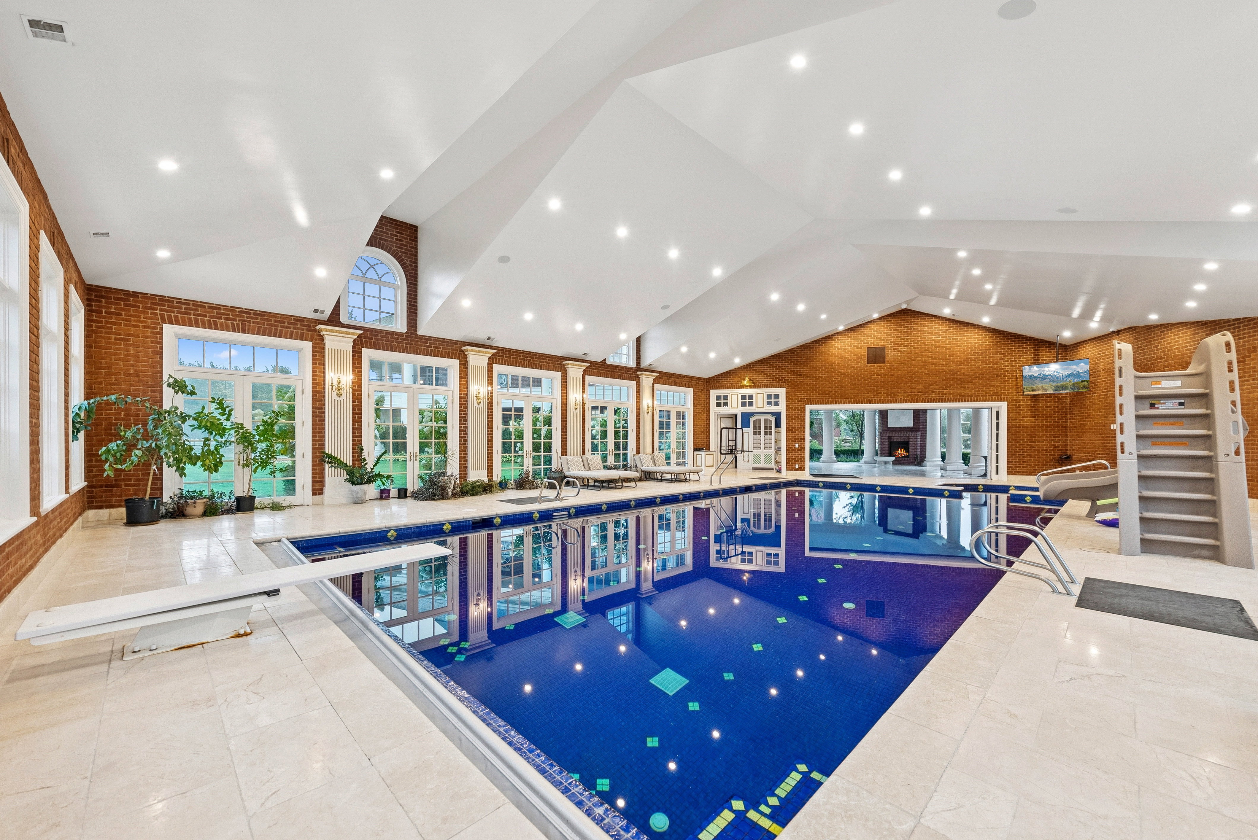 Indoor swimming pool featuring a diving board and waterslide
