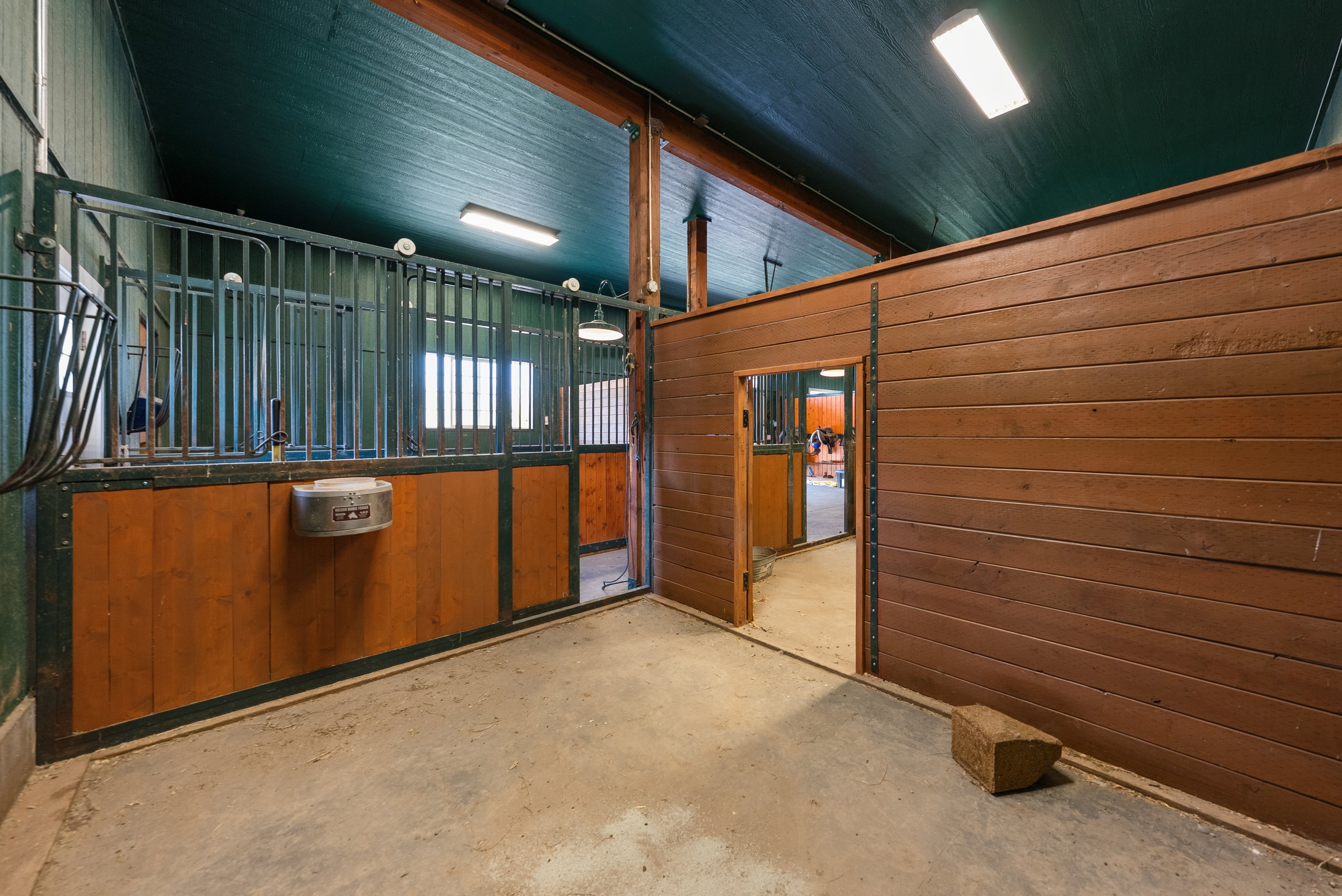 Barn interior featuring a concrete floor and rich wood-paneled walls