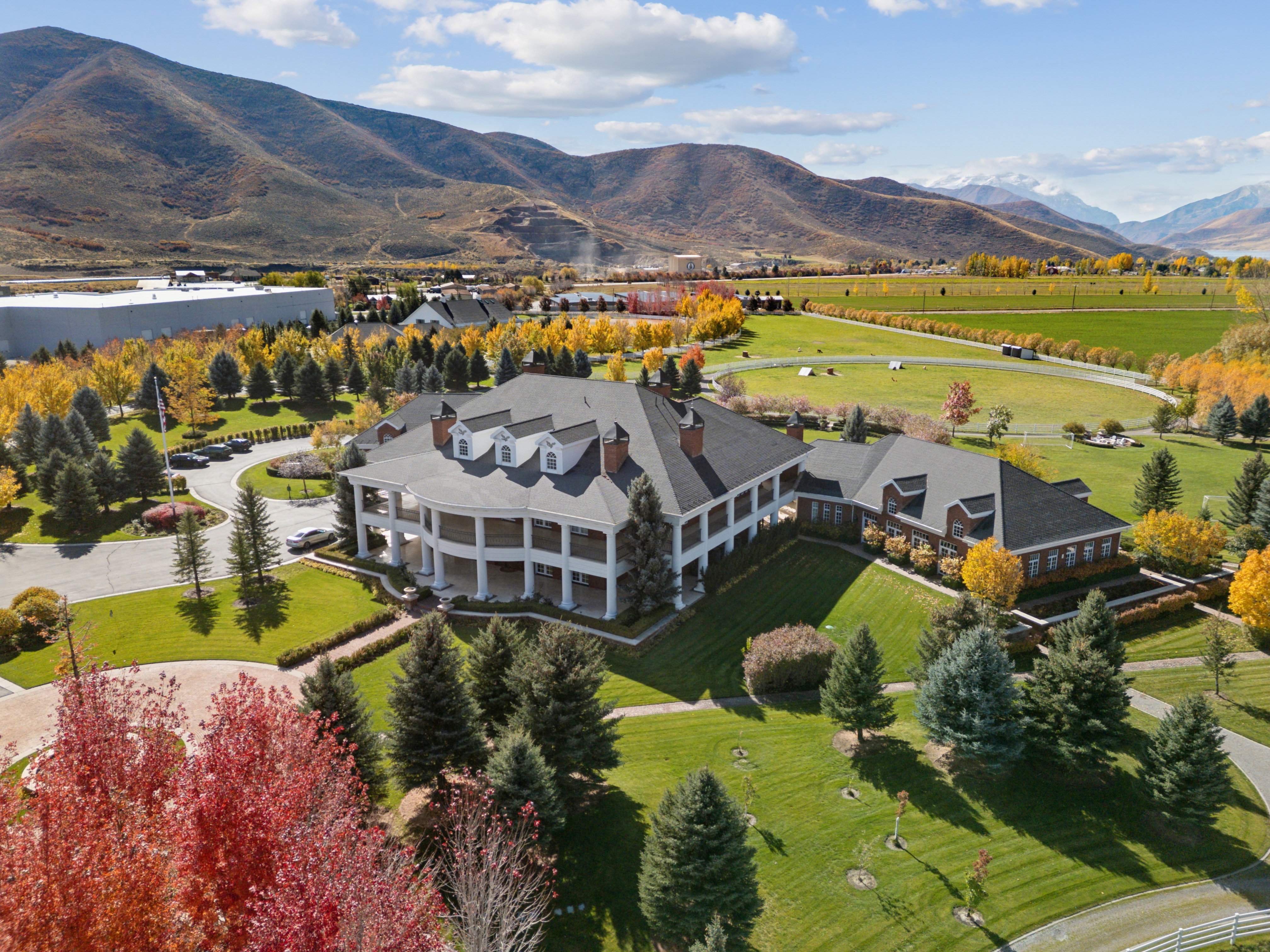 Expansive estate featuring a grand main residence with a wrap-around porch and multiple dormers