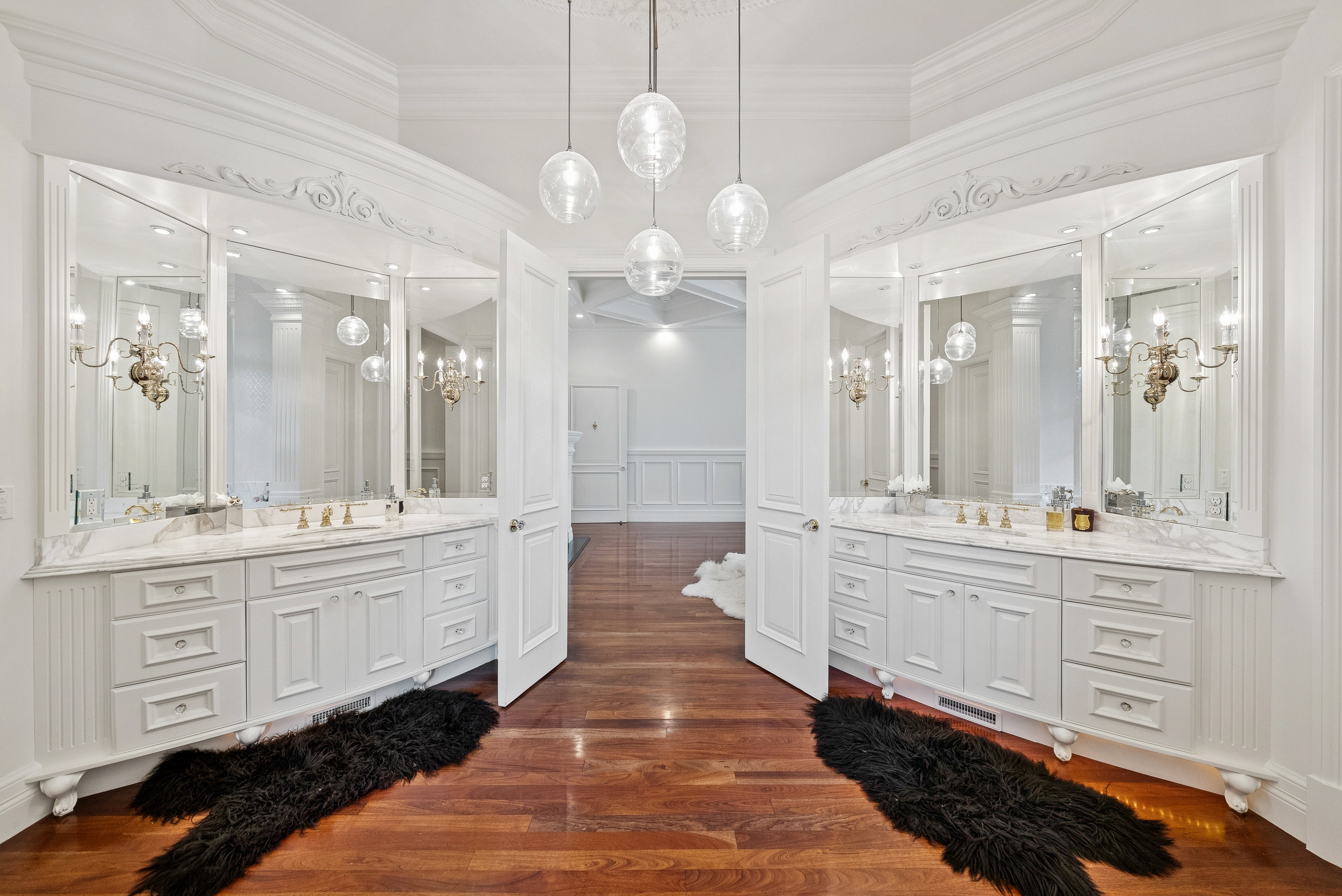 Dual vanities featuring white cabinetry, stone countertops, and integrated sinks