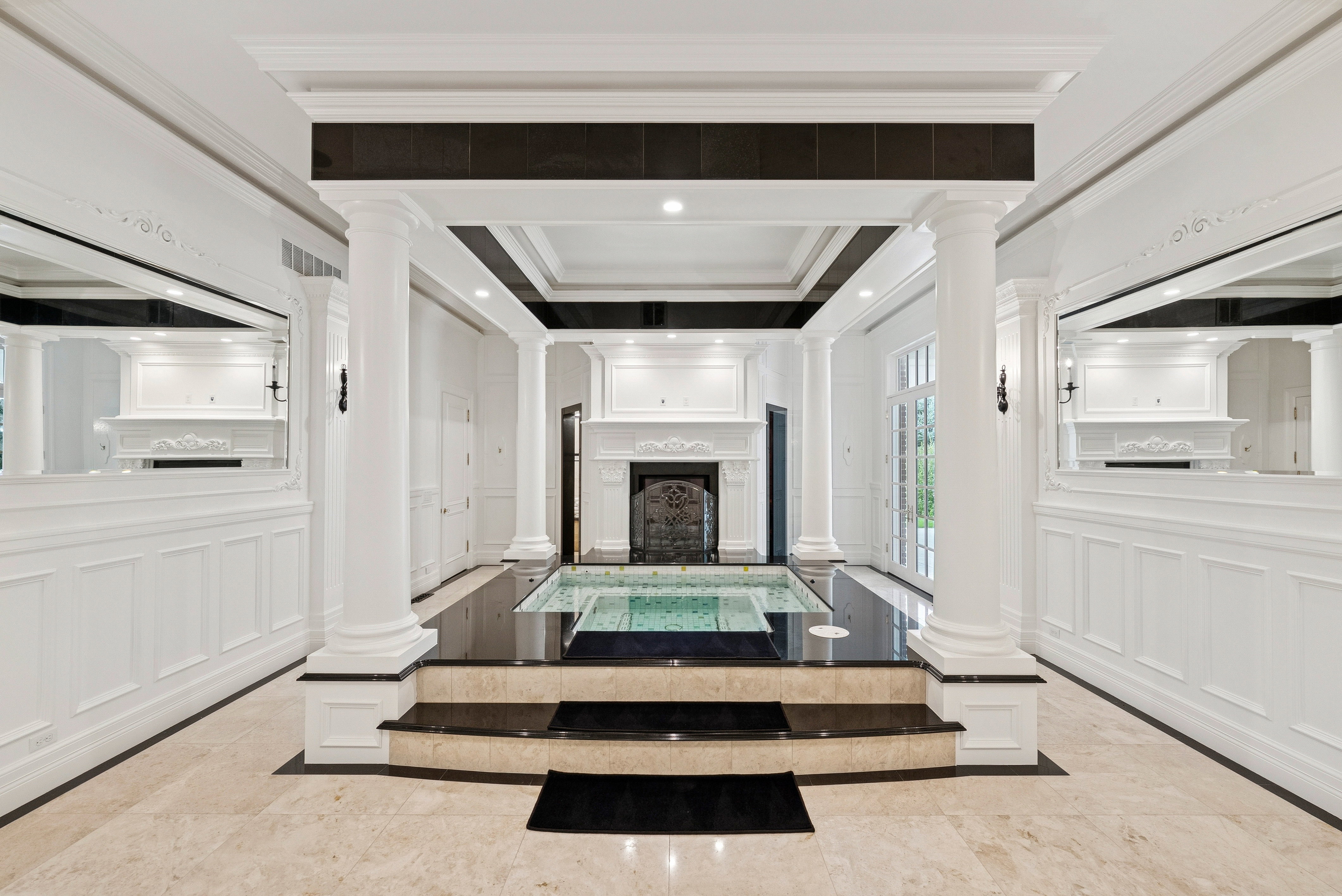 Indoor pool featuring a black tile surround, decorative iron grate, and recessed lighting