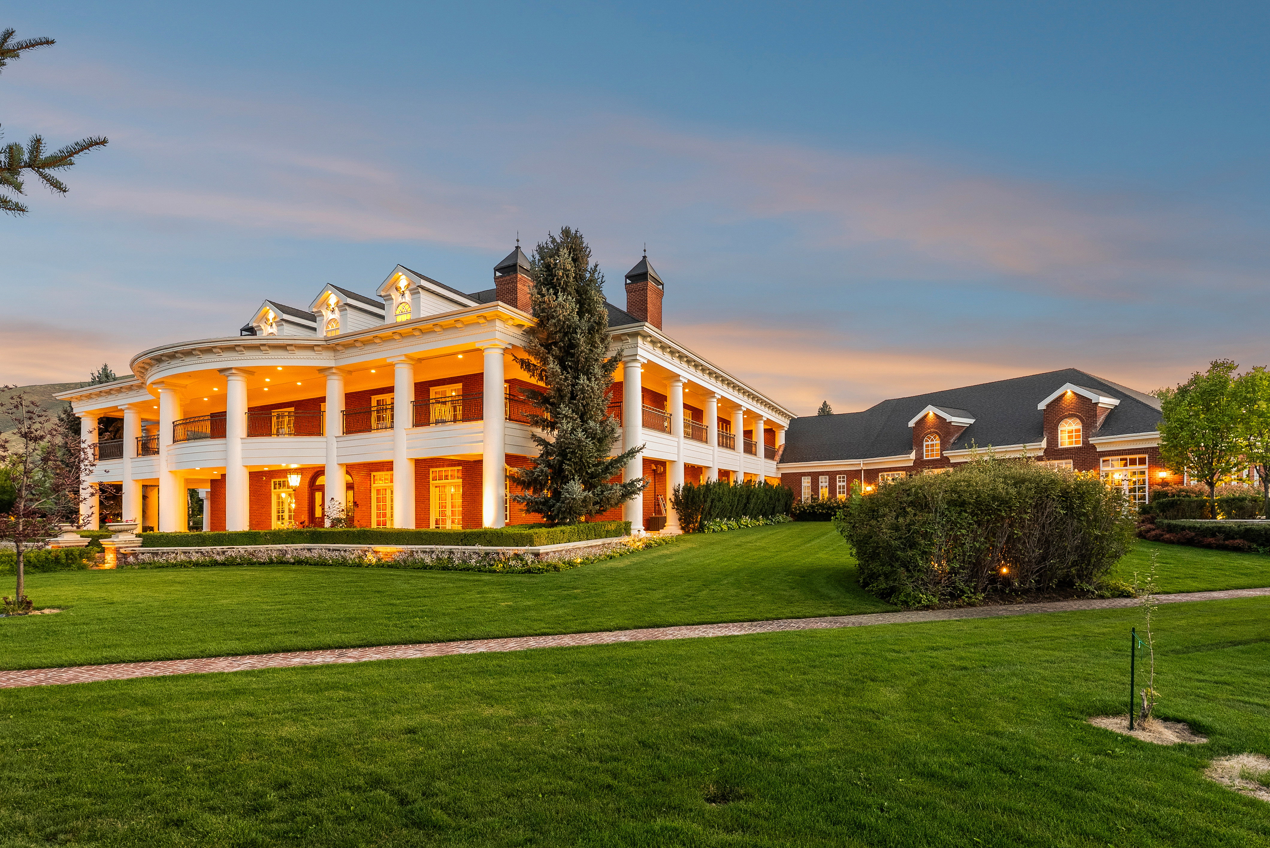 Stately brick exterior with a wrap-around porch and columns