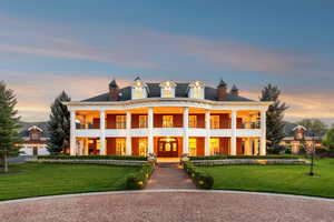 Greek revival house with a yard, a chimney, and french doors