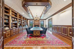 Dining area with ornamental molding, a wainscoted wall, plenty of natural light, a decorative wall, and dark wood finished floors