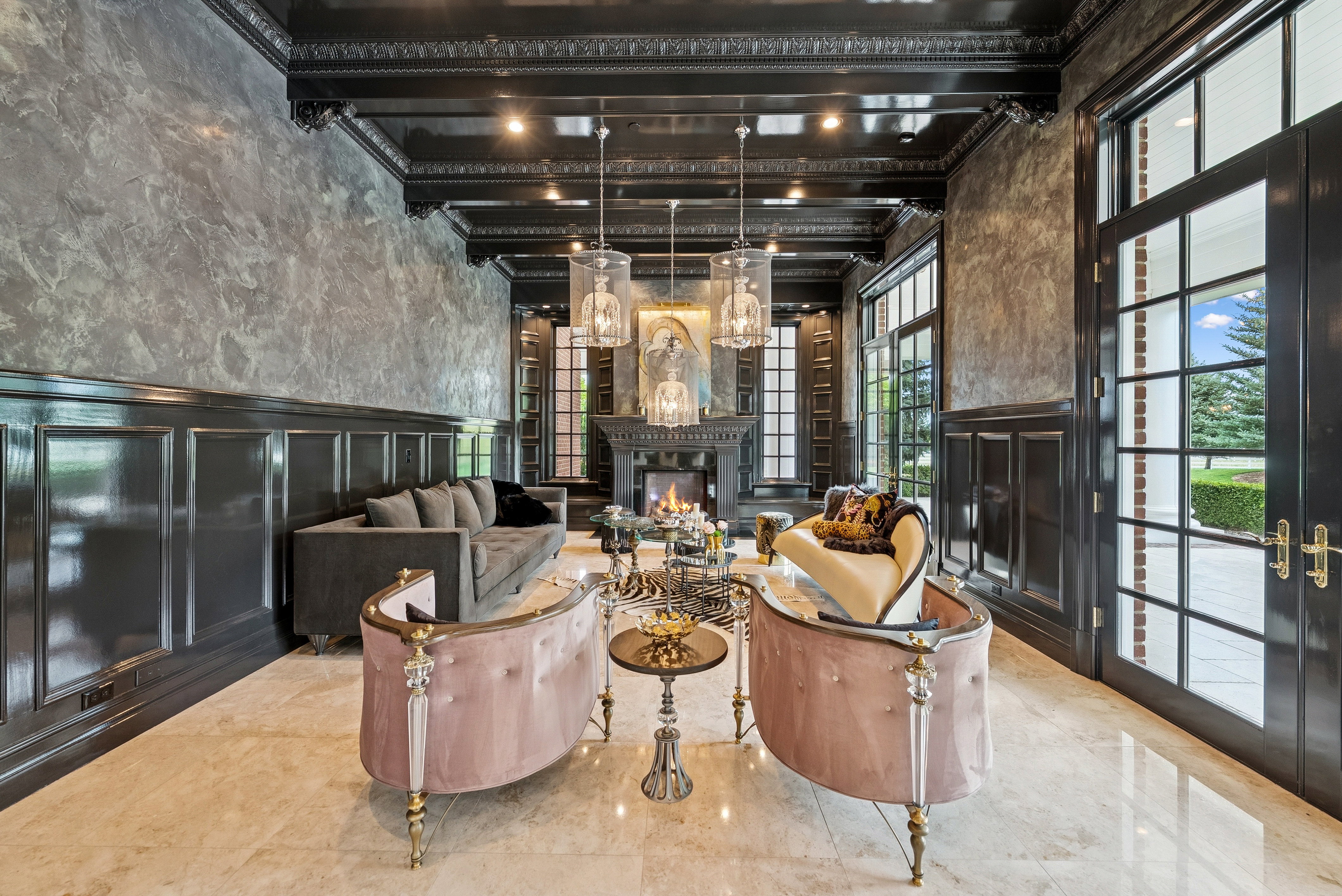 Spacious interior featuring a fireplace with built-in cabinetry, glossy coffered ceiling, wainscoting, and large paneled doors