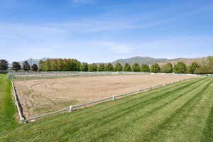 View of community featuring a mountain view, an enclosed riding area, and a view of rural / pastoral area