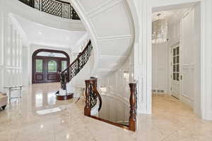 Entryway with a high ceiling, a decorative wall, a chandelier, stairway, and recessed lighting