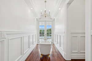 Hallway featuring french doors, crown molding, a chandelier, recessed lighting, and dark wood-type flooring