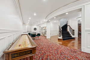Game room featuring a decorative wall, a wainscoted wall, wood finished floors, and carpet flooring