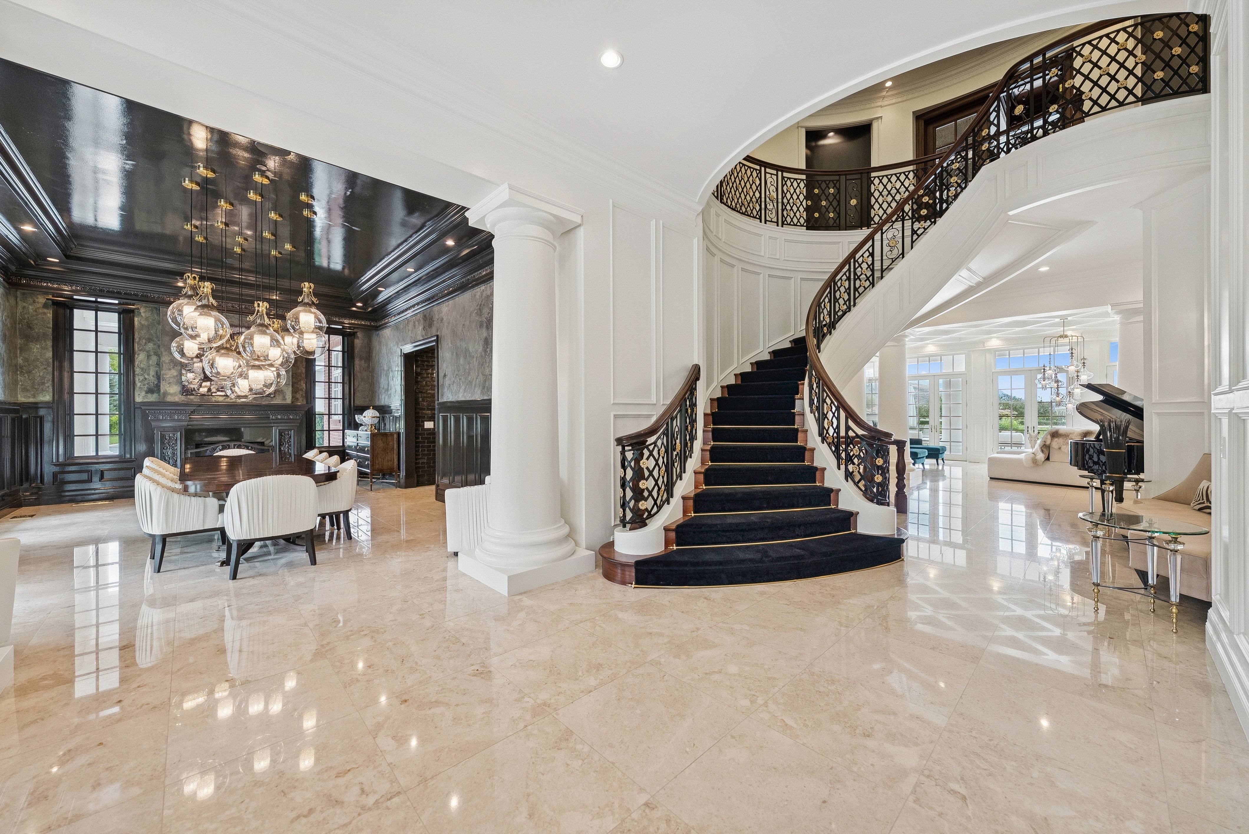 Grand foyer featuring a curved staircase with ornate metalwork railings and a carpeted tread