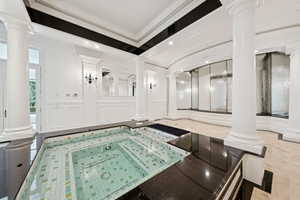 Bathroom with decorative columns, a decorative wall, crown molding, a wainscoted wall, and recessed lighting