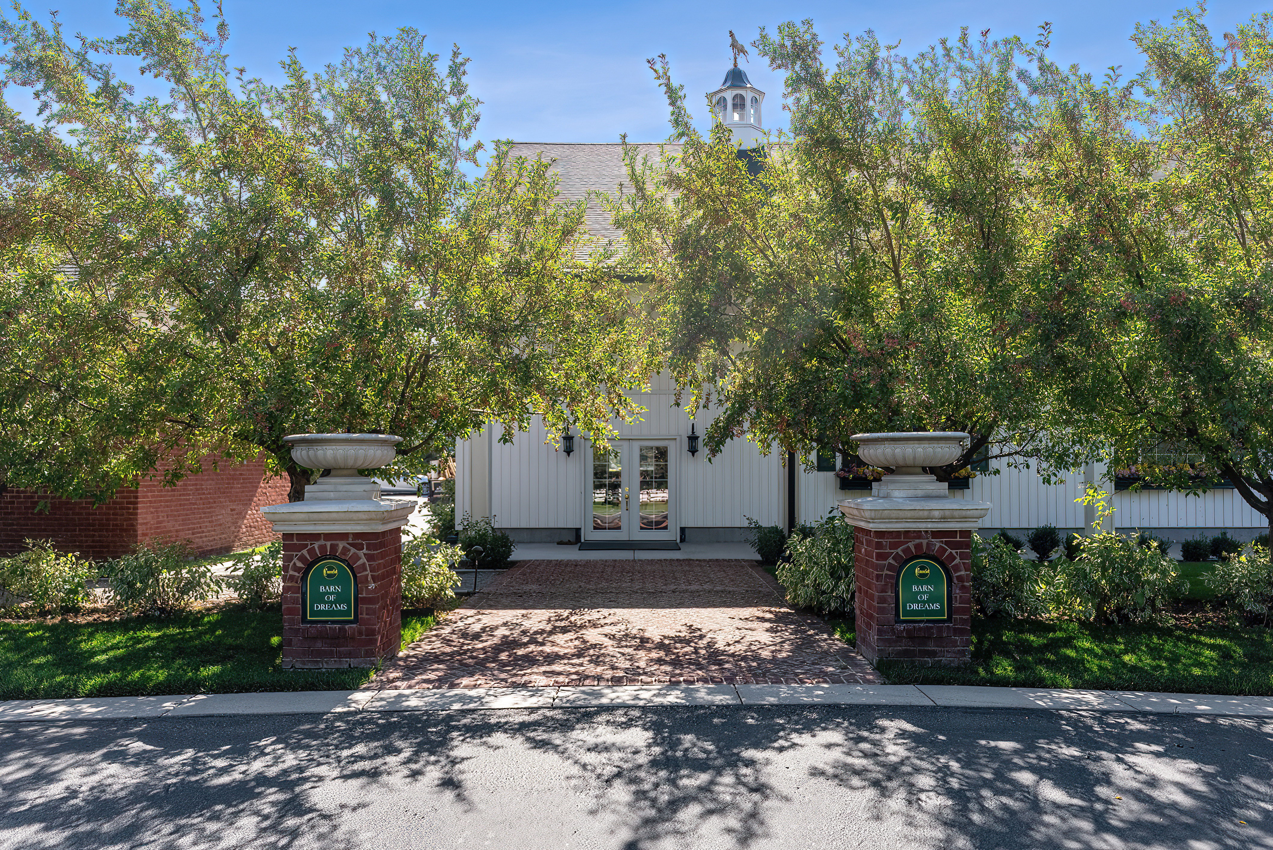 White board-and-batten exterior with a classic cupola featuring a weathervane