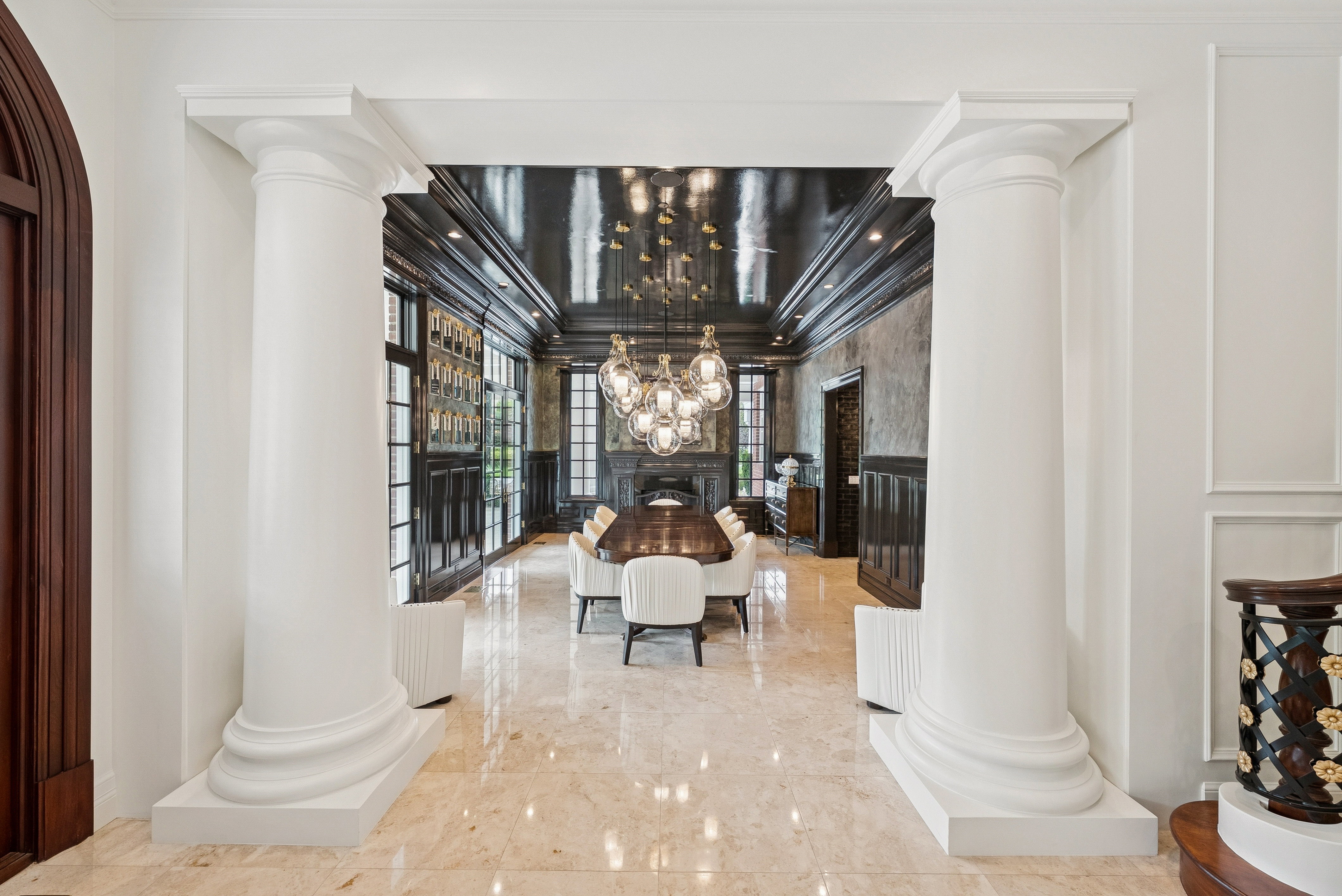Columned entryway featuring polished marble flooring