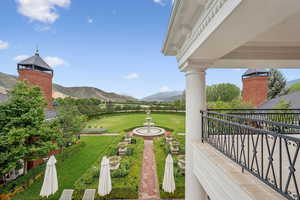 View of green lawn with a mountain view and a balcony