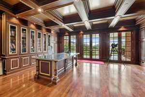 Office space featuring coffered ceiling, ornamental molding, beamed ceiling, light wood-type flooring, and french doors