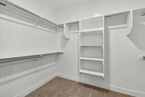 Walk in closet featuring light colored carpet