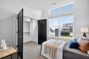 Bedroom featuring light carpet and a textured ceiling