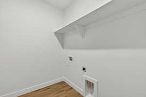 Laundry room featuring light wood-style floors, electric dryer hookup, and washer hookup