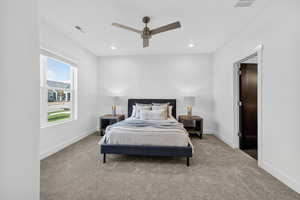 Carpeted bedroom featuring a ceiling fan and recessed lighting