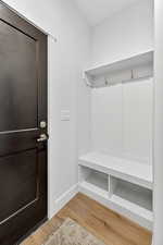 Mudroom with wood finished floors and baseboards