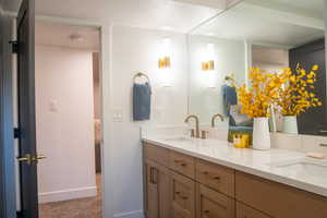 Full bath featuring double vanity and baseboards