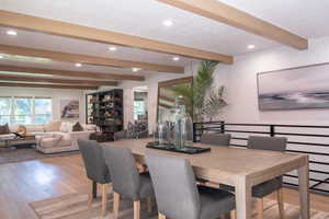 Dining area featuring beamed ceiling, light wood-style floors, and recessed lighting