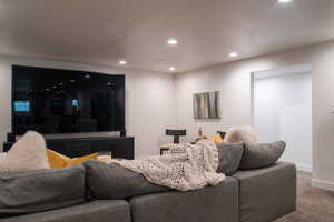 Cinema room featuring a textured ceiling, carpet, and recessed lighting