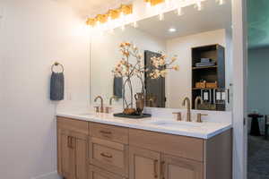 Bathroom featuring double vanity and baseboards