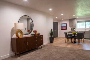 Dining room featuring recessed lighting, light colored carpet, a textured ceiling, and light wood-style floors