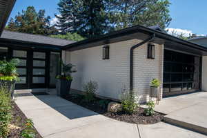 View of home's exterior with brick siding, french doors, driveway, and a garage