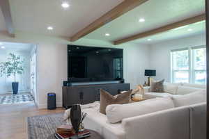 Living area featuring beam ceiling, wood finished floors, and recessed lighting