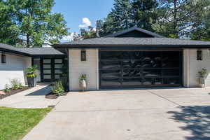 View of front of property featuring driveway, brick siding, an attached garage, and a shingled roof