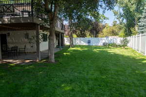 Fenced backyard with a patio and a balcony