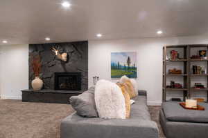 Living area featuring carpet flooring, a fireplace, and recessed lighting
