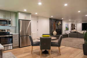 Dining space featuring light wood finished floors, recessed lighting, and a fireplace