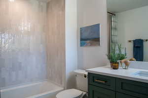Bathroom featuring shower / bathtub combination with curtain and vanity