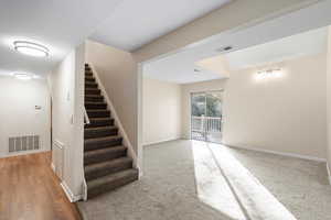 Stairway with baseboards and carpet flooring