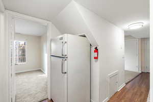 Kitchen with freestanding refrigerator and dark wood-type flooring