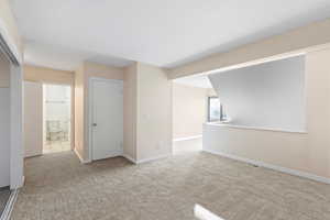Empty room featuring light colored carpet