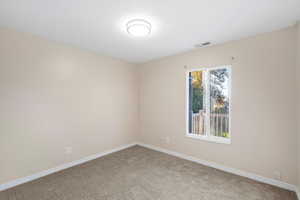 Carpeted empty room featuring baseboards