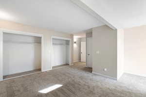 Unfurnished bedroom with carpet floors and multiple closets