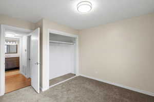 Unfurnished bedroom with light colored carpet and a closet