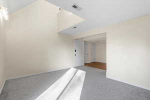 Carpeted spare room featuring baseboards