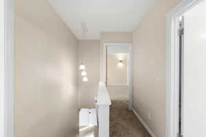 Hall with carpet flooring and an upstairs landing