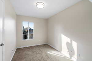 Empty room featuring carpet and baseboards