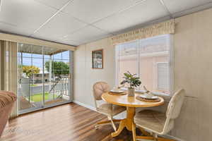 Dining space with a paneled ceiling and wood finished floors