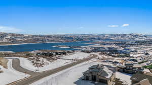 Snowy aerial view with a water and mountain view